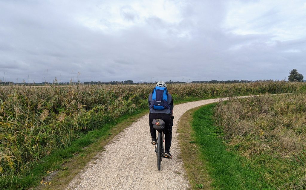 Mann mit Fahrrad auf Fernradweg