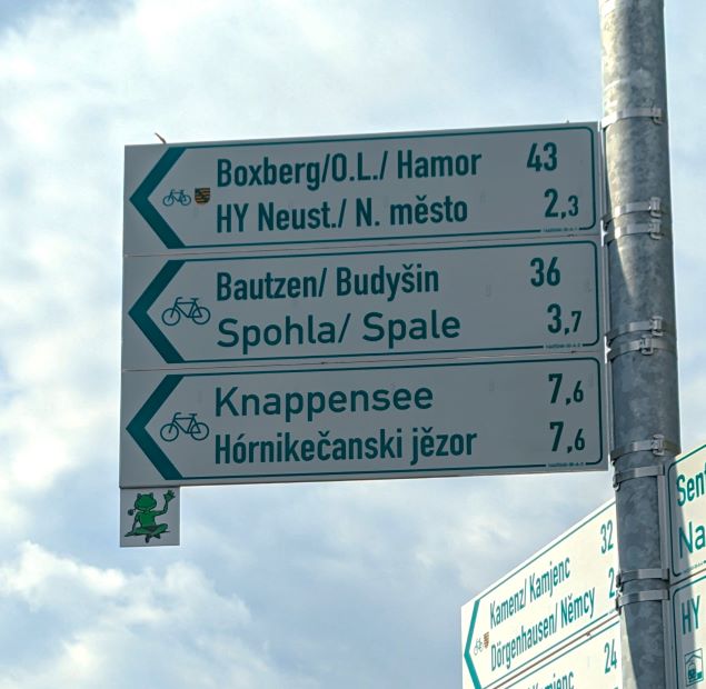 Wegweiser für den Froschradweg an einem Straßenschild.