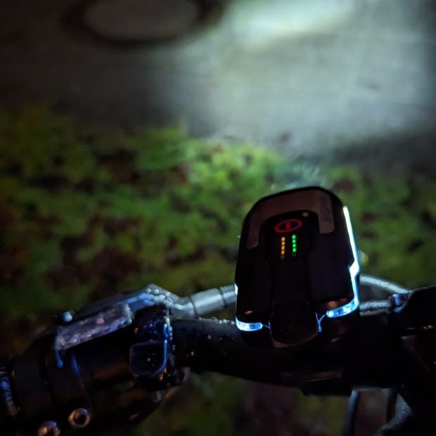 Helles Fahrradlicht am Lenker im Dunklen.