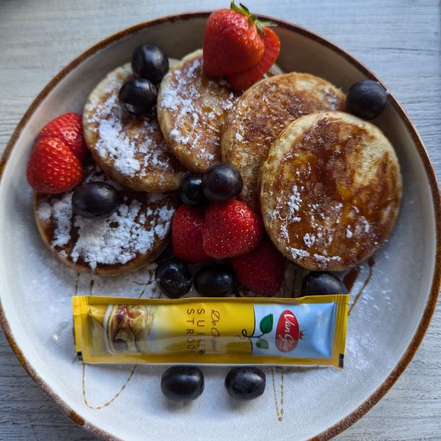 Teller mit Pancakes mit Beeren und Puderzucker