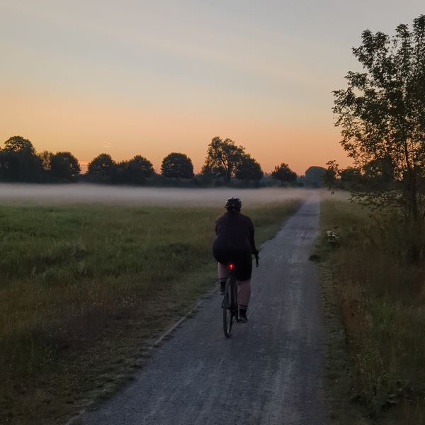 Radfahren im Herbst. Frau auf Fahrrad im Nebel.