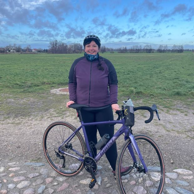 Frau mit Fahrrad im Herbst mit Fleecejacke und Multituch