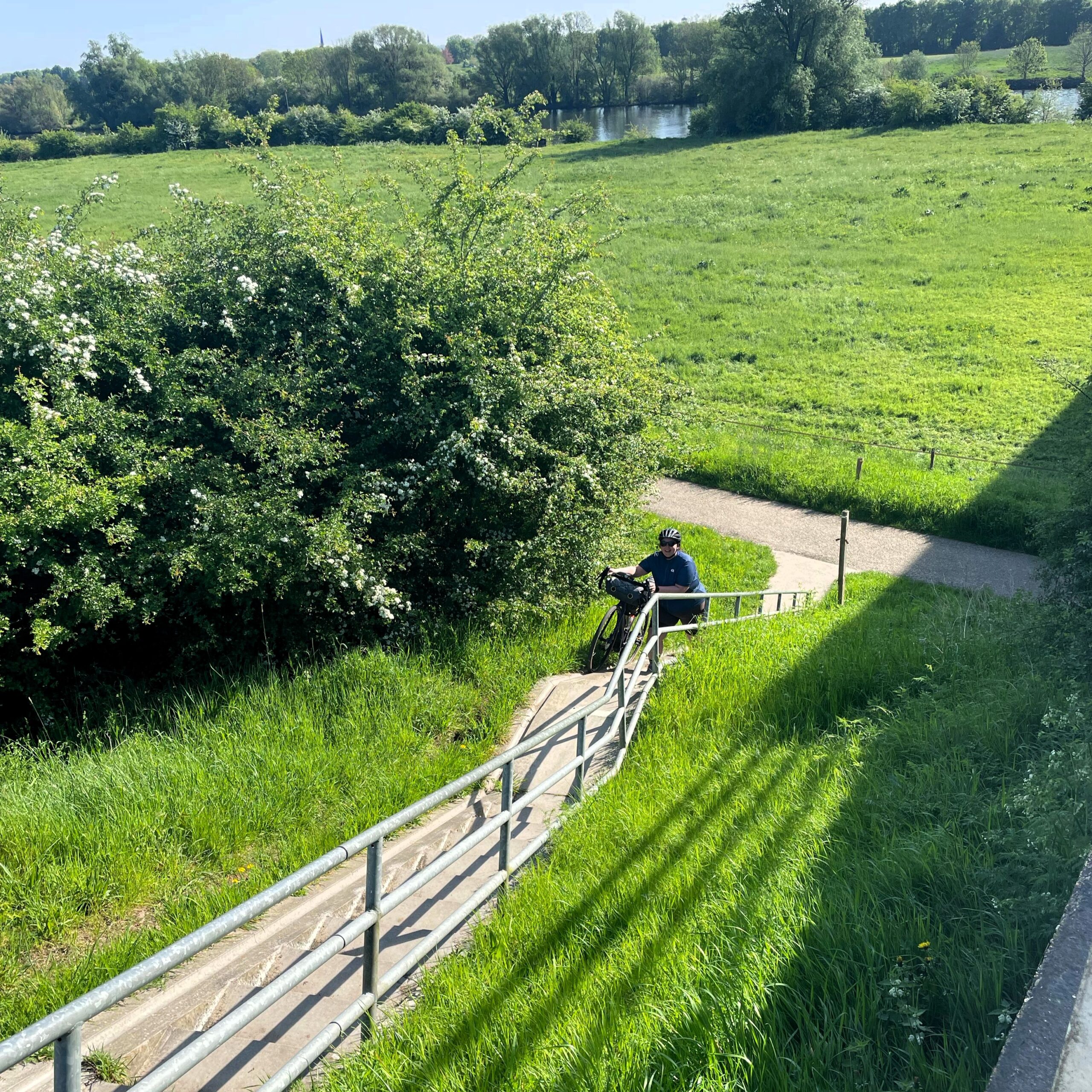 Bikepacking auf Maas- Radweg. Fahrrad wird Treppe hochgeschoben